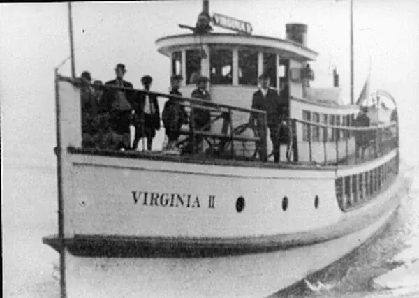 Passengers crowd the bow of the Virginia II, a small white Mosquito Fleet steamer