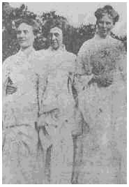 Faded newspaper photo of Dora and Claire Williamson standing with a friend